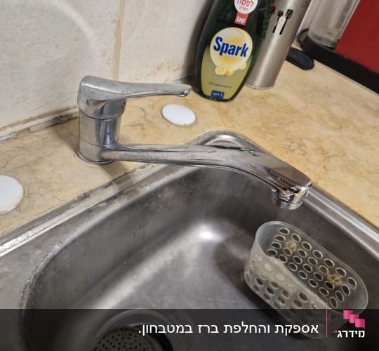 ברז נירוסטה מעל כיור מטבח עם מסננת